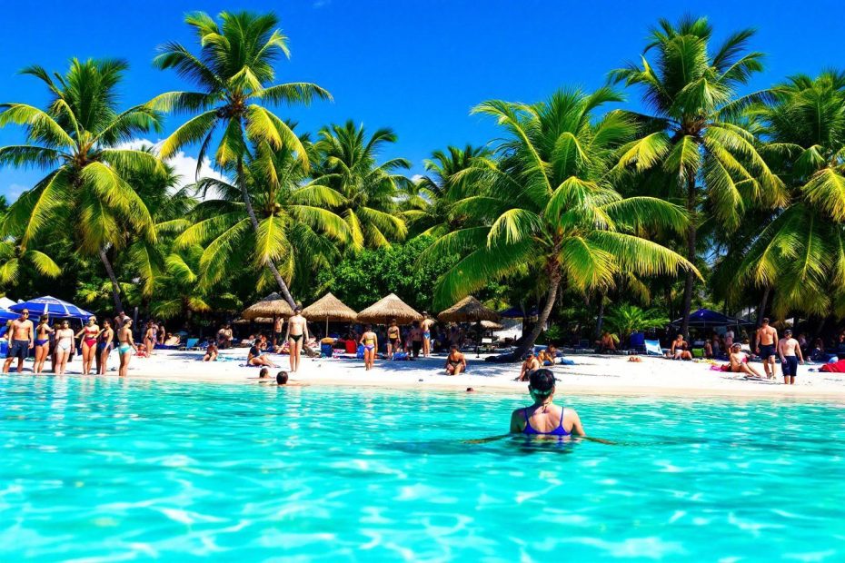 Plage de sable blanc, eau turquoise et cocotiers luxuriants