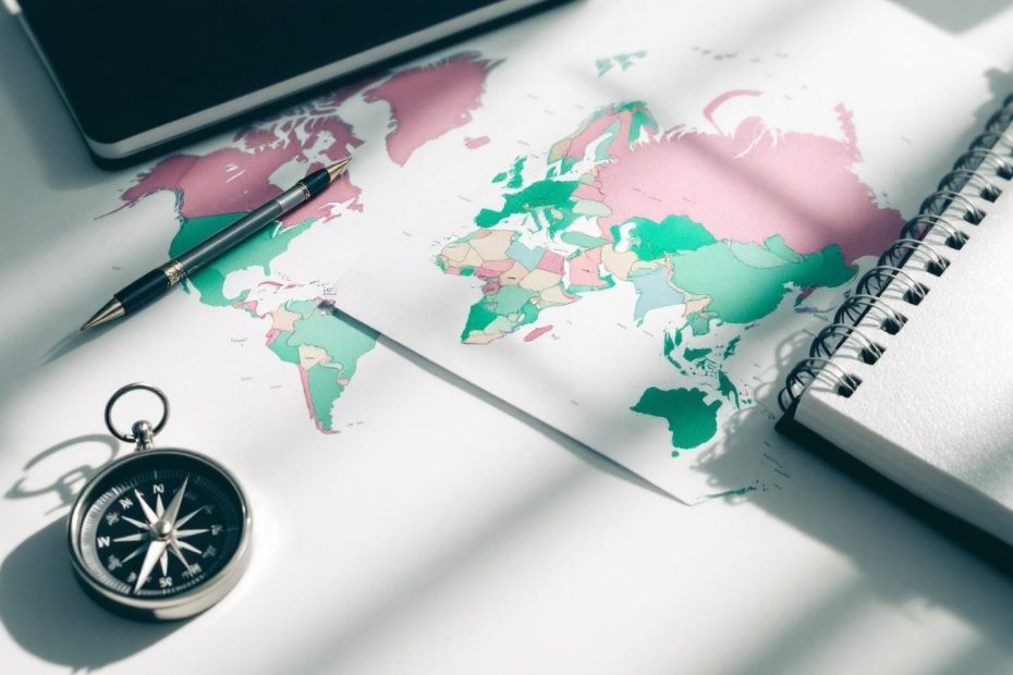 Carte colorée, boussole et stylo sur un bureau blanc