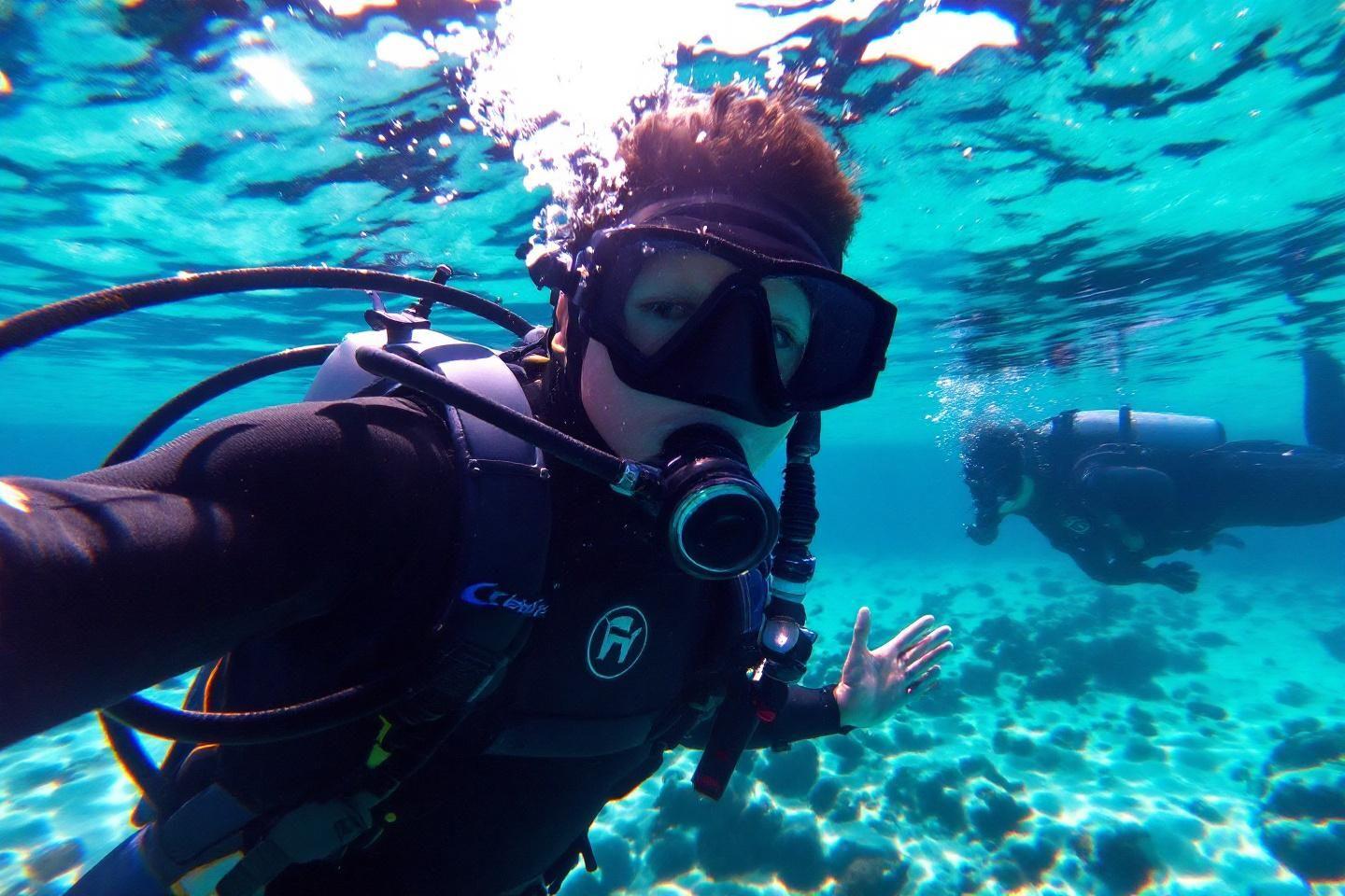 Deux plongeurs équipés explorent un récif corallien bleu