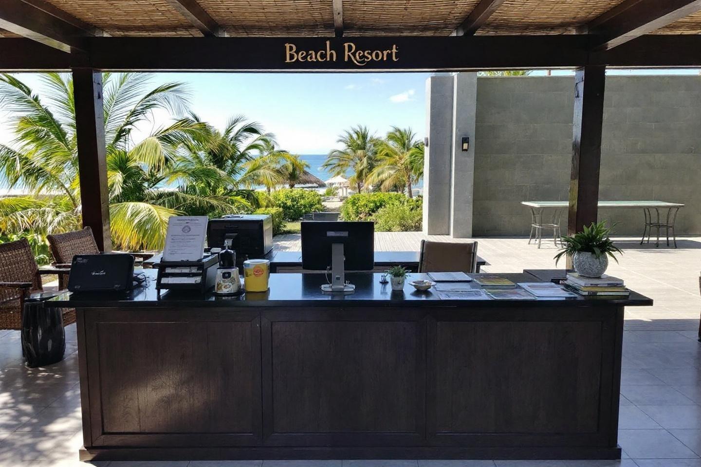 Bureau d'accueil face à la mer avec palmiers en arrière-plan